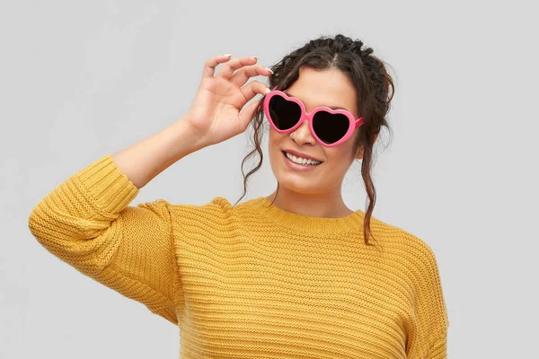 Sorridente giovane donna in occhiali da sole a forma di cuore — Foto Stock