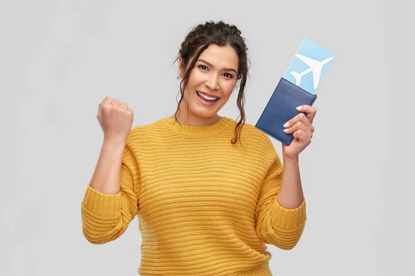 Uçak bileti ve pasaportu olan mutlu genç bir kadın. — Stok fotoğraf
