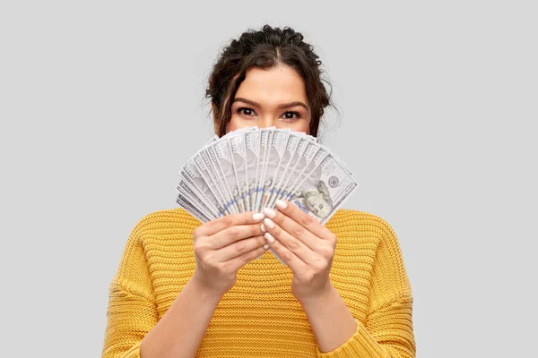 Mladá žena zakrývající si tvář dolarovými penězi — Stock fotografie