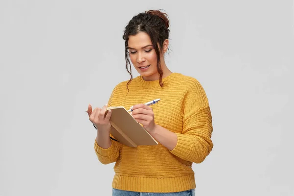 Felice giovane donna che scrive su diario o taccuino — Foto Stock