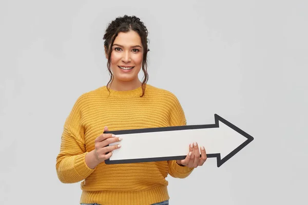 Lächelnde junge Frau mit großem weißen Pfeil nach rechts — Stockfoto