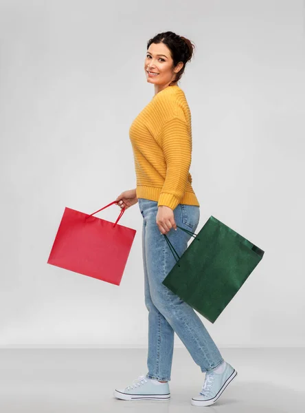 Szczęśliwa uśmiechnięta młoda kobieta z torbami na zakupy — Zdjęcie stockowe
