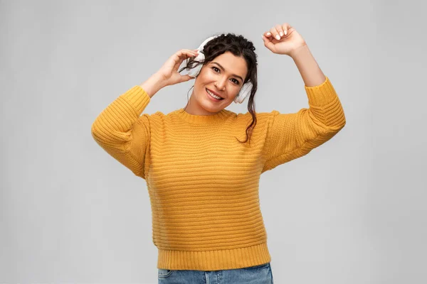Šťastná žena ve sluchátkách poslouchající hudbu — Stock fotografie