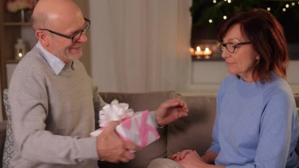 Счастливая старшая пара с подарочной коробкой дома — стоковое видео