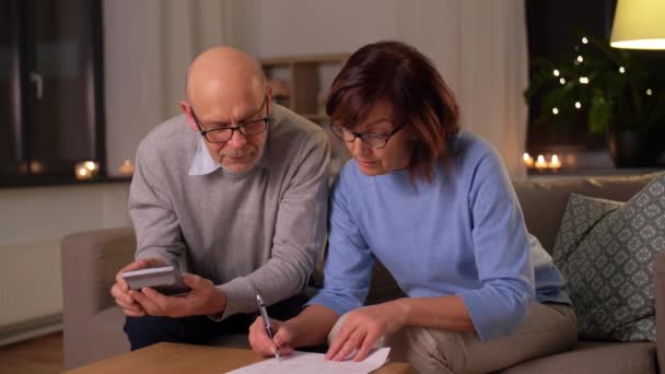 Senior couple with papers and calculator at home — Stock Video