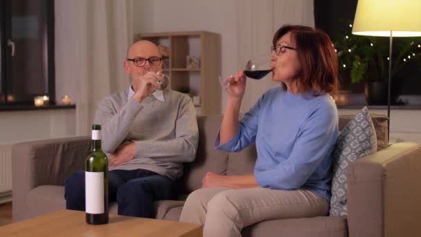 Szczęśliwy senior para pijąc czerwone wino w domu — Wideo stockowe