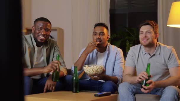 Felizes amigos do sexo masculino com cerveja assistindo tv em casa — Vídeo de Stock