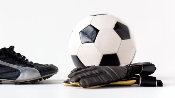 Pelota de fútbol, botas y guantes sobre fondo blanco — Vídeos de Stock