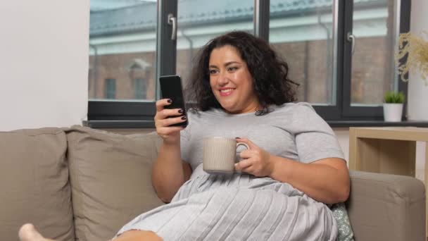 Mujer con teléfono inteligente beber café en casa — Vídeo de stock