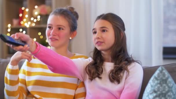 Adolescentes comiendo palomitas de maíz viendo la televisión en casa — Vídeos de Stock