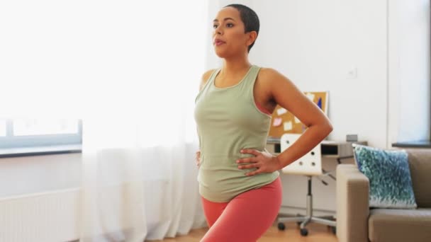 Mujer africana haciendo ejercicio de embestida en casa — Vídeo de stock