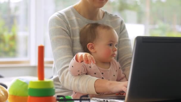 Mãe com bebê trabalhando no laptop no escritório em casa — Vídeo de Stock