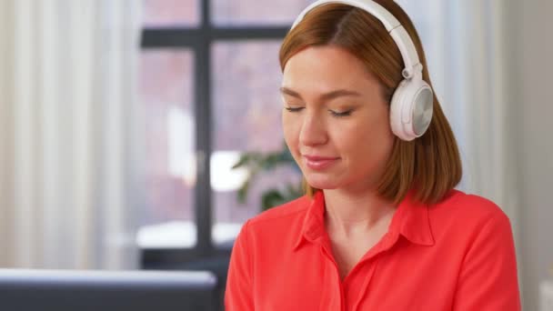 Mujer en auriculares con portátil trabajando en casa — Vídeo de stock