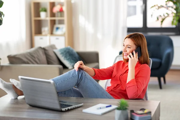 Mujer sonriente llamando en el teléfono inteligente en la oficina en casa — Foto de Stock