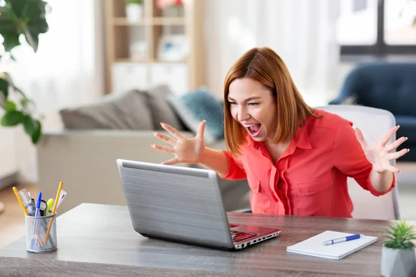 自宅のオフィスで働くノートパソコンを持つ怒っている女性 — ストック写真