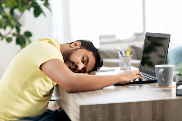 Indiaanse man slapen op tafel met laptop thuis — Stockfoto