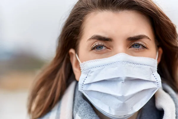 Ung kvinna bär skyddande medicinsk mask — Stockfoto