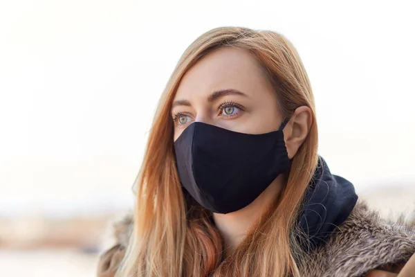 Kvinna bär skyddande återanvändbar barriär mask — Stockfoto