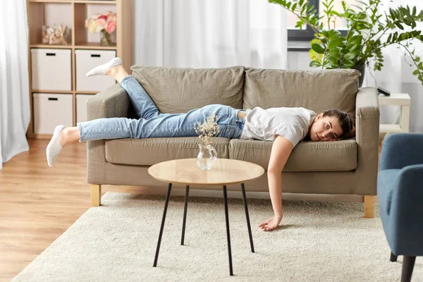 Ennuyée ou paresseuse jeune femme allongée sur le canapé à la maison — Photo