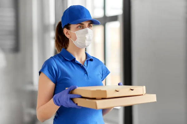 Kobieta w masce do twarzy z pudełkami po pizzy — Zdjęcie stockowe