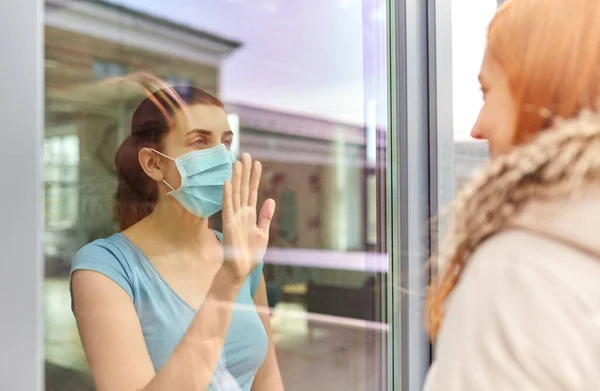 Wanita sakit dalam topeng melihat teman melalui jendela — Stok Foto