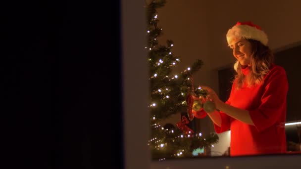 Mujer feliz decorando el árbol de Navidad con la bola — Vídeos de Stock