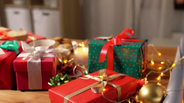 Noel hediyeleri, mum ve çelenk ışıkları evde. — Stok video