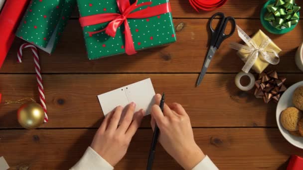 Руки прикріплюють мітку назв до різдвяного подарунка — стокове відео