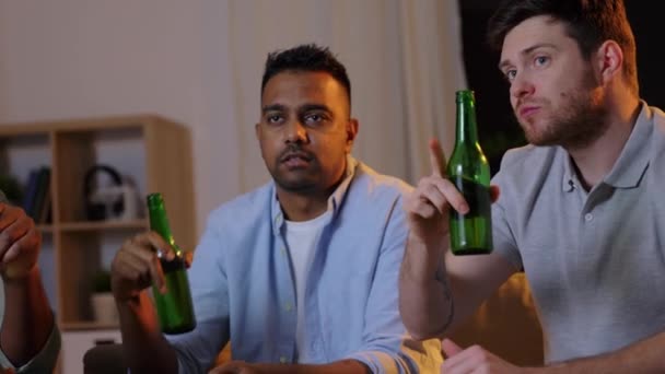 Mannelijke vrienden die bier drinken en thuis tv kijken — Stockvideo