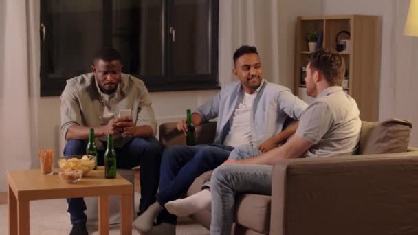 Mannelijke vrienden die bier drinken en thuis praten — Stockvideo