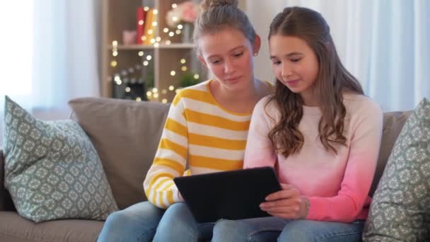 Χαρούμενα έφηβα κορίτσια με tablet υπολογιστή στο σπίτι — Αρχείο Βίντεο