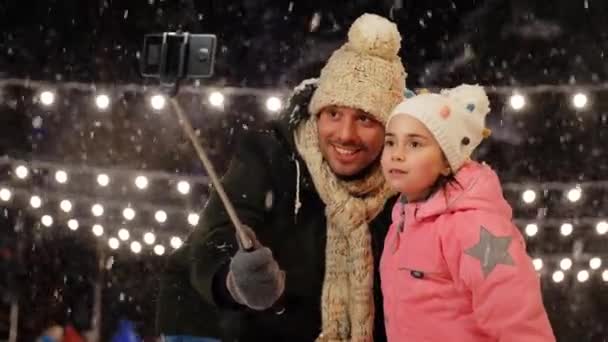Père et fille prenant selfie sur patinoire — Video