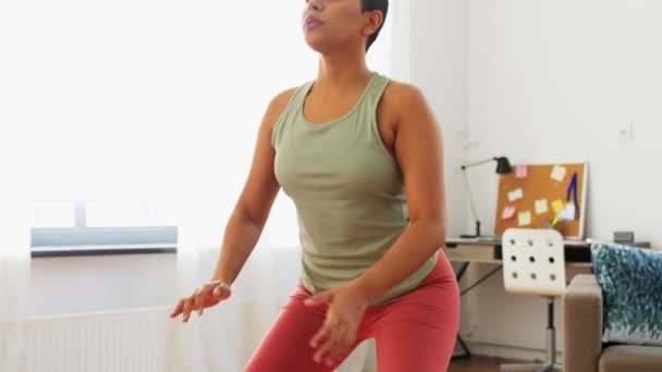 Afrikansk kvinna motionerar och gör knäböj hemma — Stockvideo