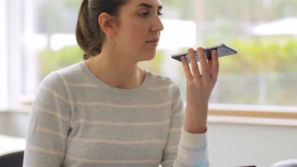 Женщина со смартфоном записывает голос в офисе — стоковое видео