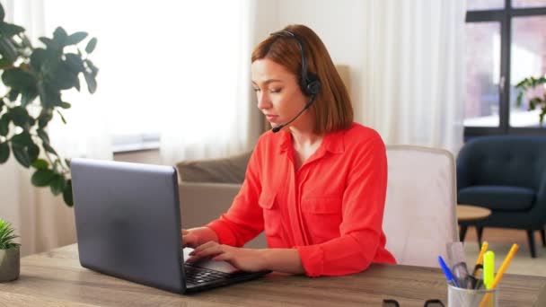 Mujer con auriculares y laptop trabajando en casa — Vídeo de stock