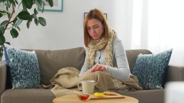 Zieke jonge vrouw drinken thee met citroen thuis — Stockvideo