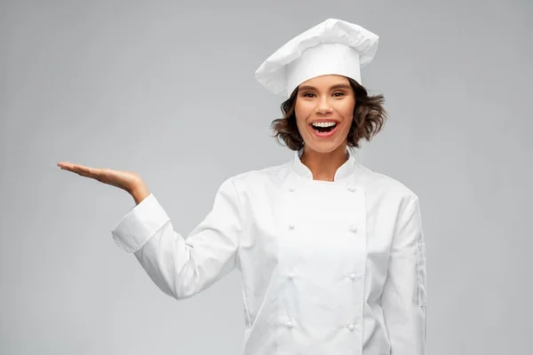 손에 무언가를 들고 있는 미소짓는 여성 요리사 — 스톡 사진