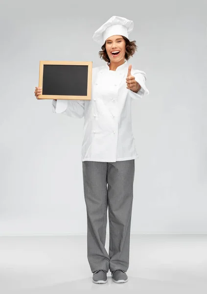 Šťastný kuchař s tabulí ukazující palce nahoru — Stock fotografie