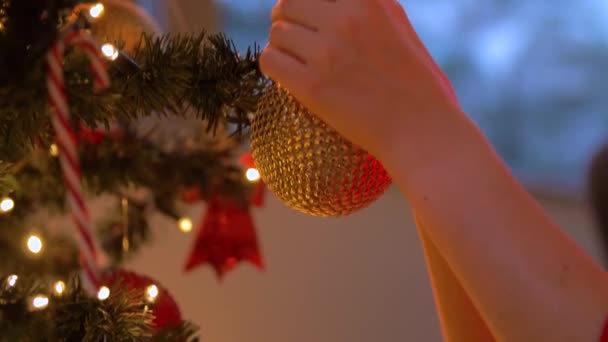 Vrouw versieren kerstboom met bal — Stockvideo