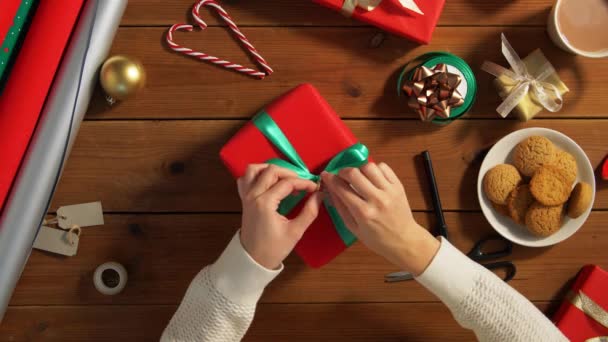 Hände kleben Namensschild an Weihnachtsgeschenk — Stockvideo