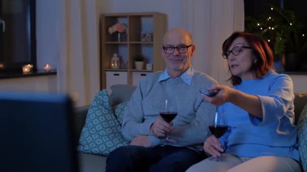 Glad senior par dricka rött vin och titta på tv — Stockvideo