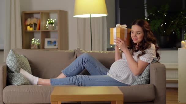 幸せな笑顔妊娠中の女性とギフトボックスで自宅 — ストック動画