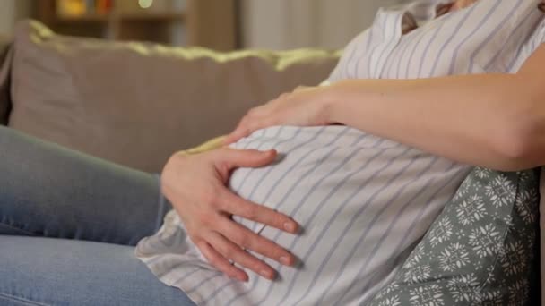 Gelukkig zwanger vrouw knuffelen haar buik thuis — Stockvideo