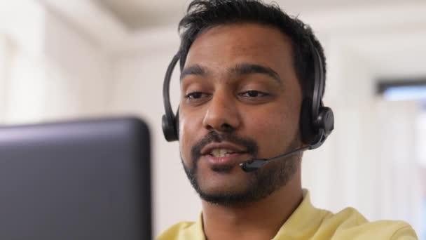 Indianin z słuchawkami i laptopem pracujący w domu — Wideo stockowe