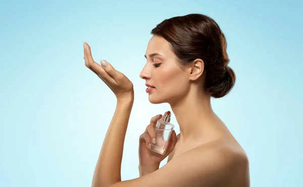 Happy woman smelling perfume from her wrist — Stock Photo, Image