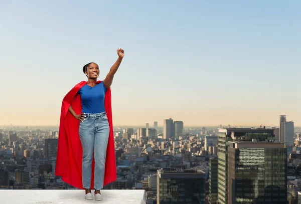 Gelukkig afrikaanse amerikaanse vrouw in rood superheld cape — Stockfoto