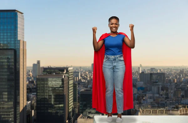 Happy african american woman in red superhero cape — Stok Foto