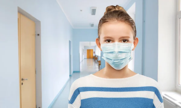 Adolescente em máscara médica sobre corredor escolar — Fotografia de Stock