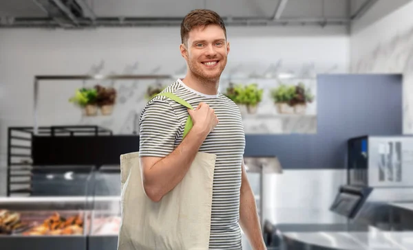 Man med återanvändbar duk väska för mat shopping — Stockfoto