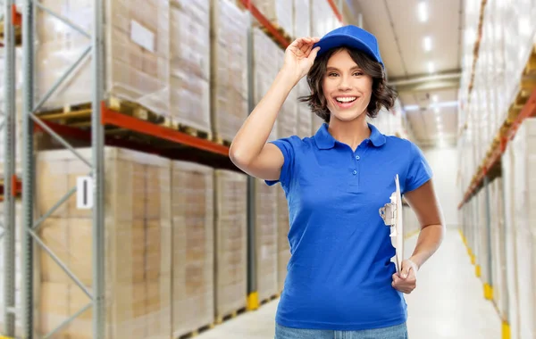 Happy delivery girl with clipboard at warehouse — Stock Photo, Image